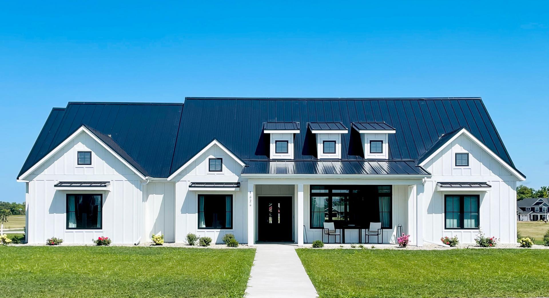 Luxury SIP home with white exterior, dark standing-seam roof, and clean modern farmhouse lines